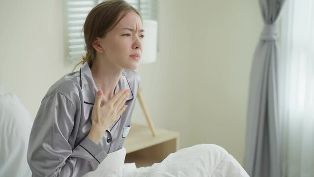 Caucasian beautiful sick girl in pajamas get up from sleep in bedroom.