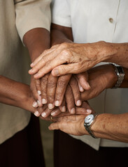 Close up of elderly people putting their hands together. Friends with stack of hands showing supporting each other