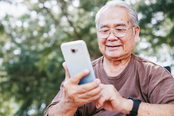 Elderly man with technology and leisure activity concept. Asian retirement elderly using smartphone