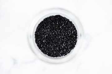pantry jar with black rice shot from top down perspective as close-up, simple staple ingredients