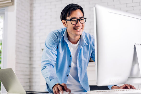 Young smiling asian man using laptop computer working and study with document at home.Young creative man with new startup project.work from home concept