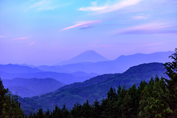 数々の山並みの向こうにそびえる富士山が夕暮れを迎えています
Mt. Fuji towering over many mountains is welcoming dusk