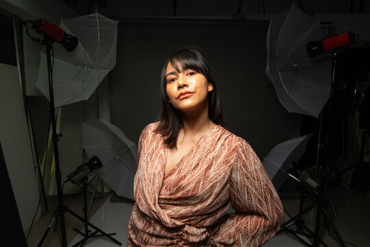 Asian Indian woman show beautiful smile happy lips, fashion poses in photo studio with equipment