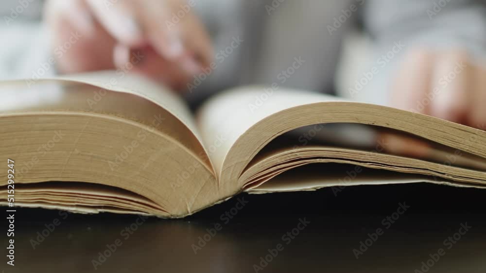 Poster read books in library. studying of the scientific material. person reads a book and scrolls through 