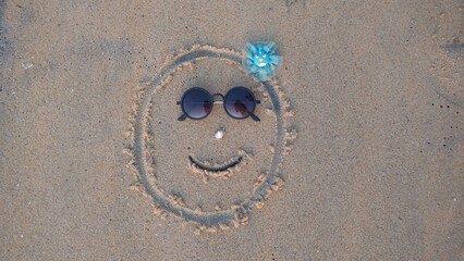 A decorated face drawn on the beach