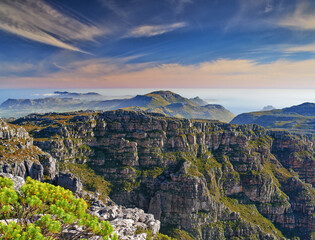 Copy space with scenic landscape at the peak of Table Mountain in Cape Town with cloudy blue sky background. Breathtaking and magnificent views of the beauty in nature after a hike up a rocky region