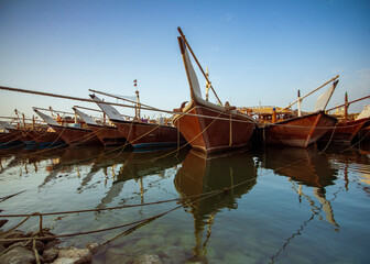 Kuwait fish port with old wood fishing boat and reflection 