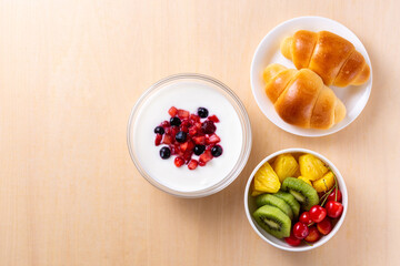 朝食のヨーグルトとパンとフルーツ