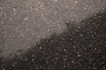 Top view of an asphalt path interspersed with white pebbles