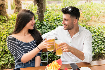 Romantic young couple toasting each other with cold beer