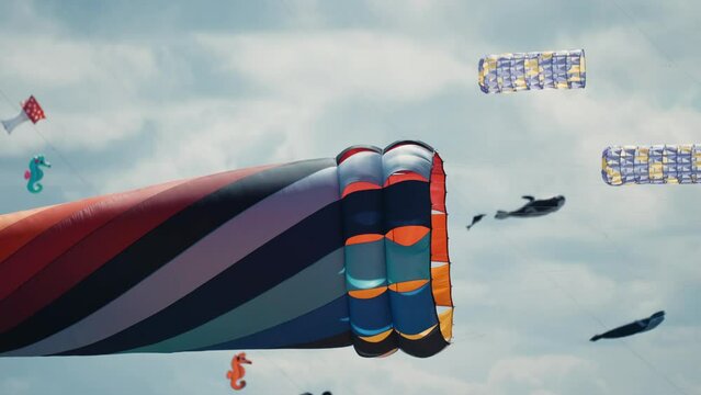 A close-up shot of parafoil kites floating in the air at the Romo kite festival. Pan follow.