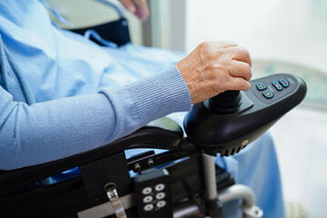 Asian elderly woman disability patient sitting on electric wheelchair in park, medical concept.