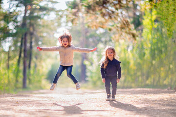 Two little girls jumping outdoors