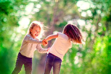 Naklejka premium Two little girls dancing outdoors