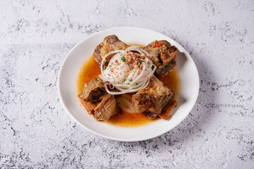 fried meat with fresh onions. on a light concrete background