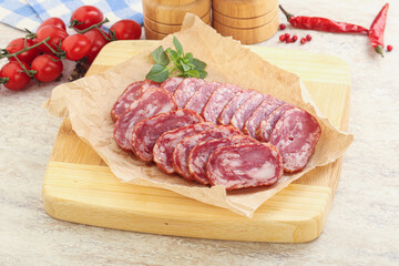 Sliced salami sausages over board