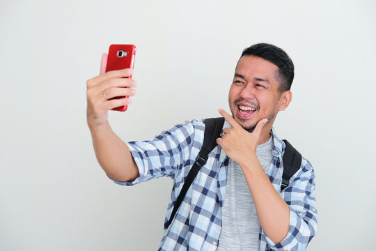 Adult Asian man taking a selfie photo with happy expression