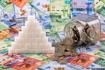 Pieces of refined sugar folded in the form of a pyramid and Kazakhstani money - tenge