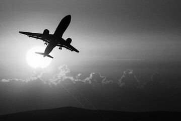 passenger plane silhouette Taking off from the airport. Passenger plane in the sky at sunrise or...