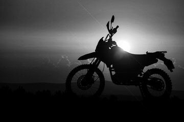 Obraz na płótnie Canvas Silhouette of a motocross motorcycle of an adventurous tourist in the evening.
