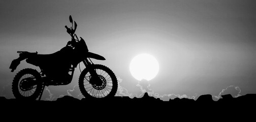 Silhouette of a motocross motorcycle of an adventurous tourist in the evening.