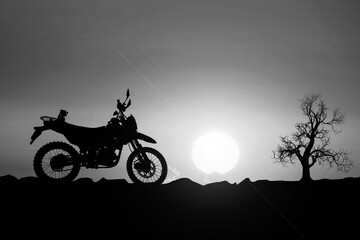 Silhouette motocross in arid areas. adventure traveler with a motorcycle.