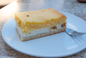 Eierschecke cake on a white plate with a fork