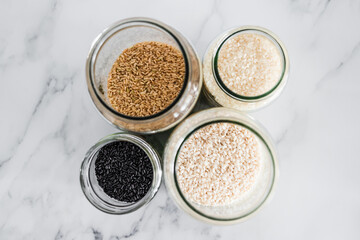 pantry jars with different types of rice including black brown arborio and sushi rice, simple...