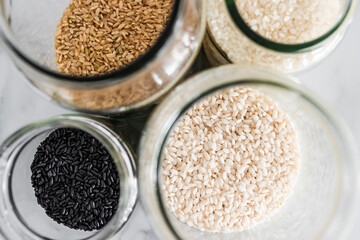 pantry jars with different types of rice including black brown arborio and sushi rice, simple...