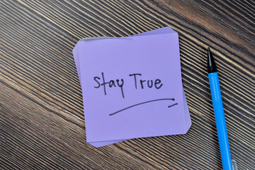 Concept of Stay true write on sticky notes isolated on Wooden Table. - obrazy, fototapety, plakaty