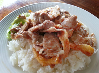 close-up stir fried garlic with slice pork top over rice with cucumber and soup Thai local food
