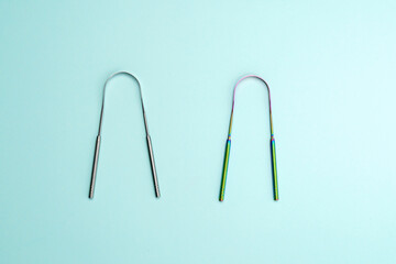 A metal scraper or brush for cleaning the tongue. Oral hygiene. Top view - obrazy, fototapety, plakaty
