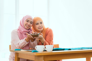 A group of Muslim female friends are having fun at the dining room table.