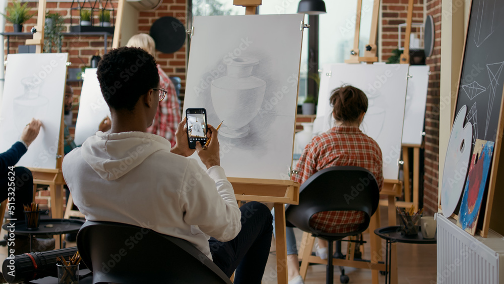 Aufkleber creative student taking picture of vase sketch on smartphone in art class. young man using mobile ph
