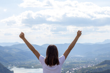 kid,little boy or woman,girl,with both raised hands,beautiful mountains background,sunny summer day.freedom concept,trip,travel,tourism concept.view at heights,amazing landscape