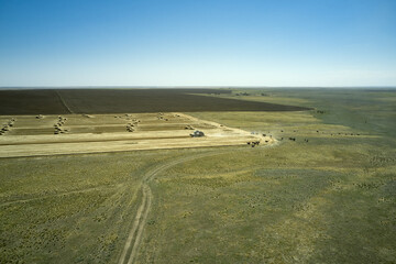 a combine harvester harvesting a field of wheat against a blue sky rural landscape
