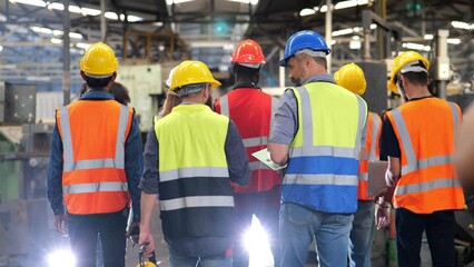 4k slow motion video, group of diversity teamwork, engineers, technician and workers team in safety uniform workwear having discussion while walking through heavy industry manufacturing factory. - Powered by Adobe