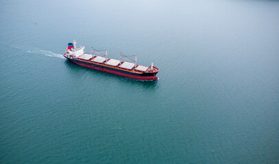 a large bulk carrier transports grain at sea, aerial view