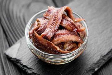canned anchovy fillet on a black wooden rustic background