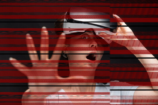 Portrait of young had shocked screaming woman removing VR glasses and reaches hand. Red stripes of online disconnection at foreground. Black background. The concept of metaverse and cyberspace