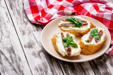 sandwich with anchovy fillet on a tray for serving on a wooden rustic background