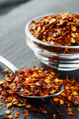 spicy chili flakes on a dark stone background