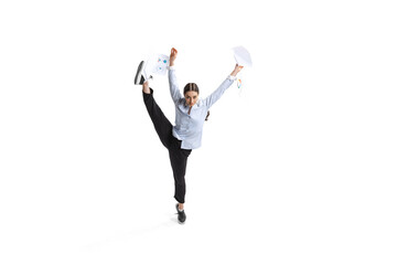 Portrait of female employee, office worker throwing papers in jump isolated over white background. Finishing project.