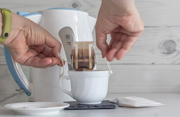 the process of removing used drip bags with coffee from the cup