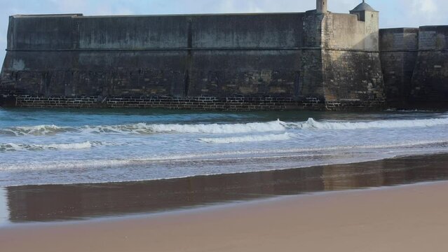 Relaxing slow motion view of small waves crashing onto beach