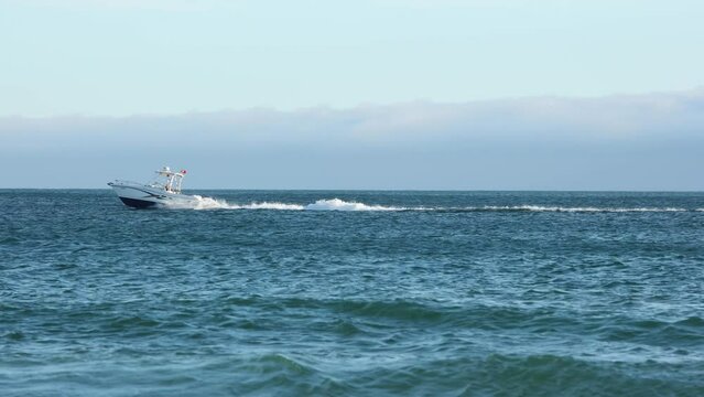 Aerial drone video of motor speed boat cruising open ocean deep blue sea.