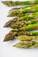 raw green asparagus on a white acrylic background