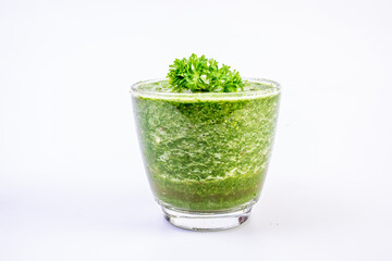 Healthy green kale smoothie in a glass isolated on white table background. Kale is considered a superfood because it's a great source of vitamins and minerals.