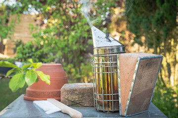 Beekeeping Equipement in a Green Garden with visible Smoke
