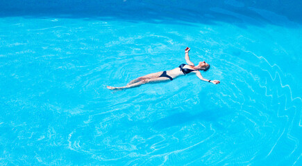 top view of woman floating in swimming pool